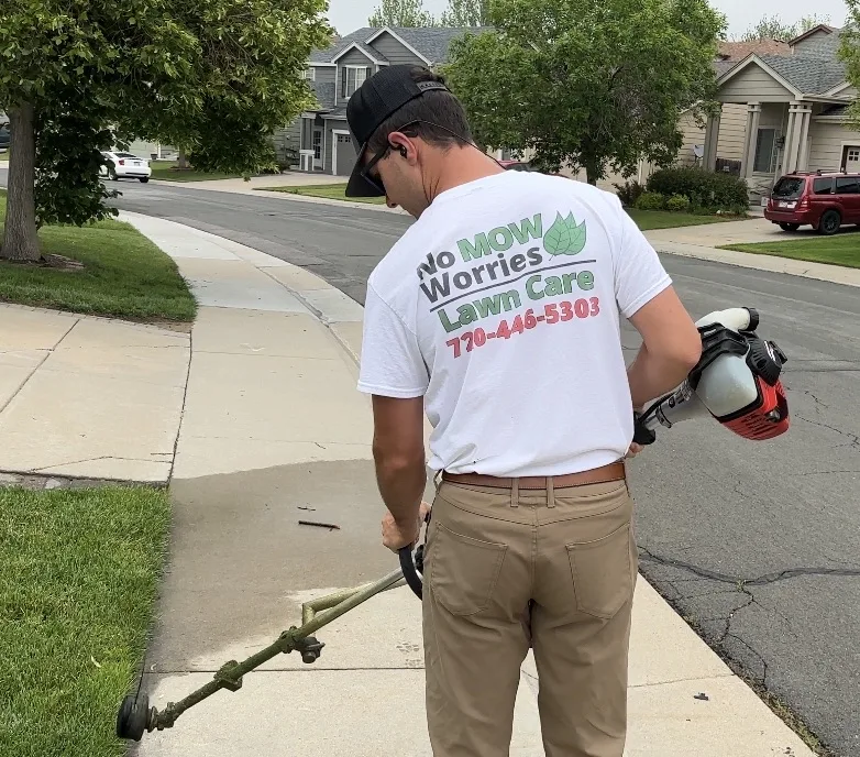 Crew member edging lawn in Aurora, CO